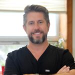 A man with beard and mustache wearing black shirt